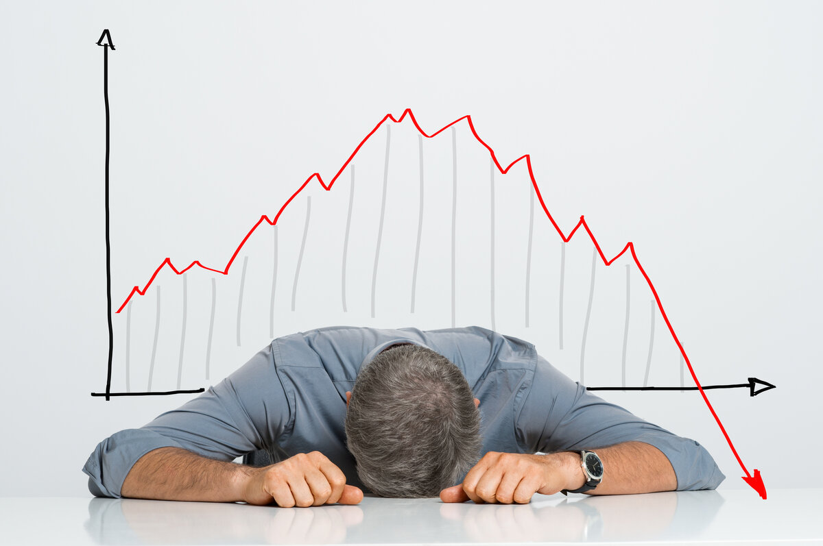 investing graph behind man laying on desk
